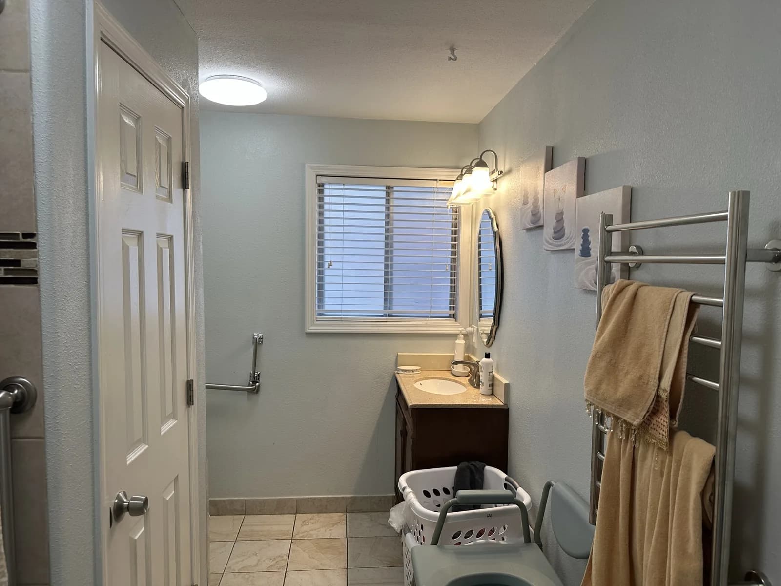 Angel Light bathroom with a roll-in shower, shower chair, and wall-mounted grab bars.