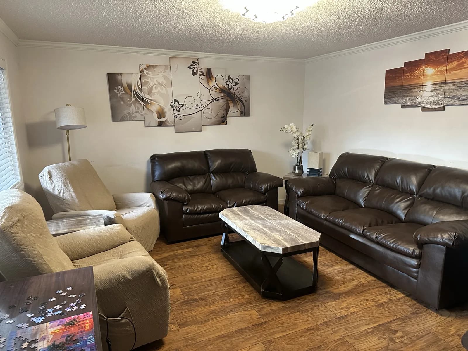 Angel Light living room with leather sofas, recliners, and a marble-pattern coffee table.